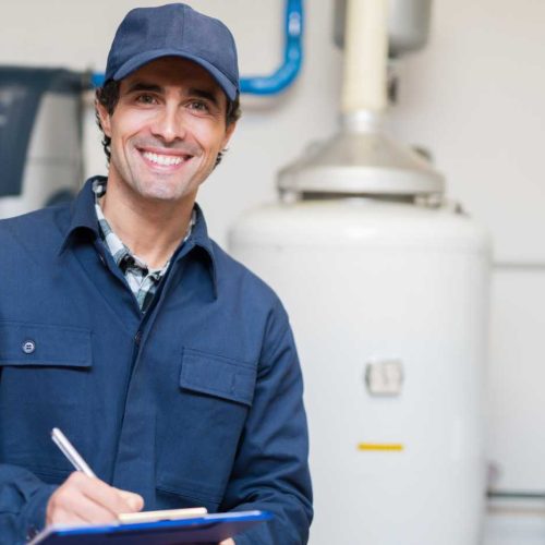 Smiling handyman in uniform holding a clipboard in a utility room, ready to provide professional repair and maintenance services